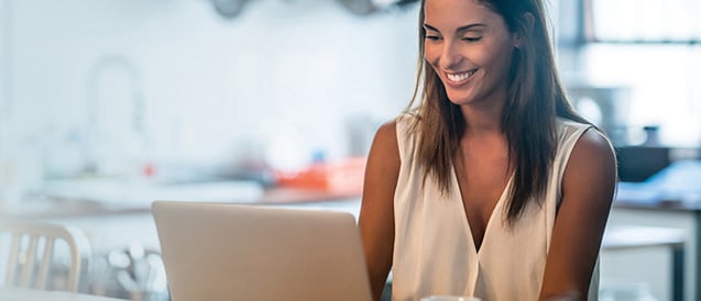 Woman using laptop to read article on media centre.