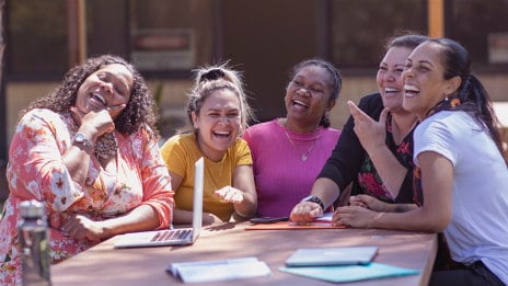 Group of women sitting at a table outside.