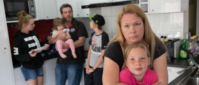 Image of young family in their kitchen.