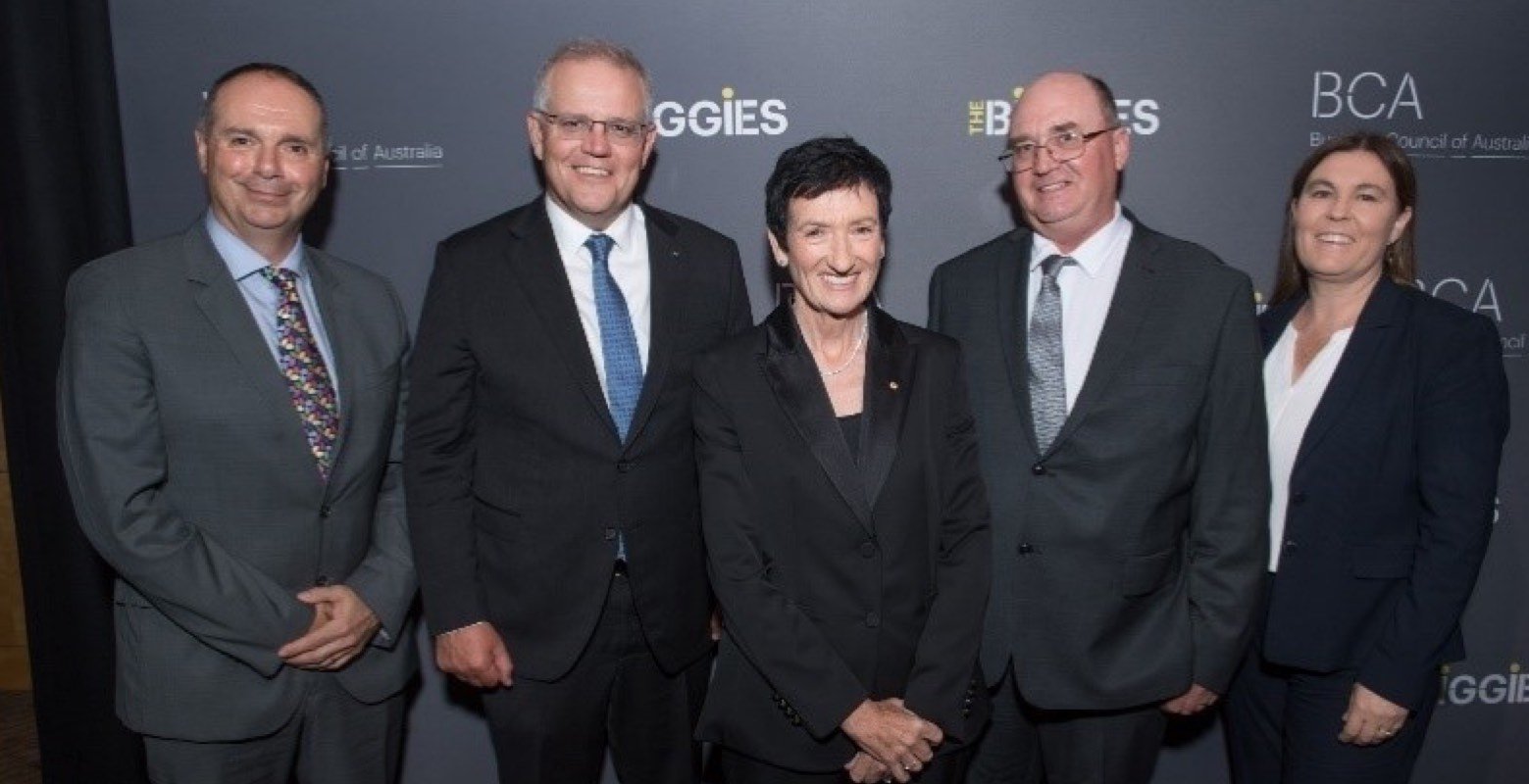 Image of Biggies Awards winners standing in front of logo wall