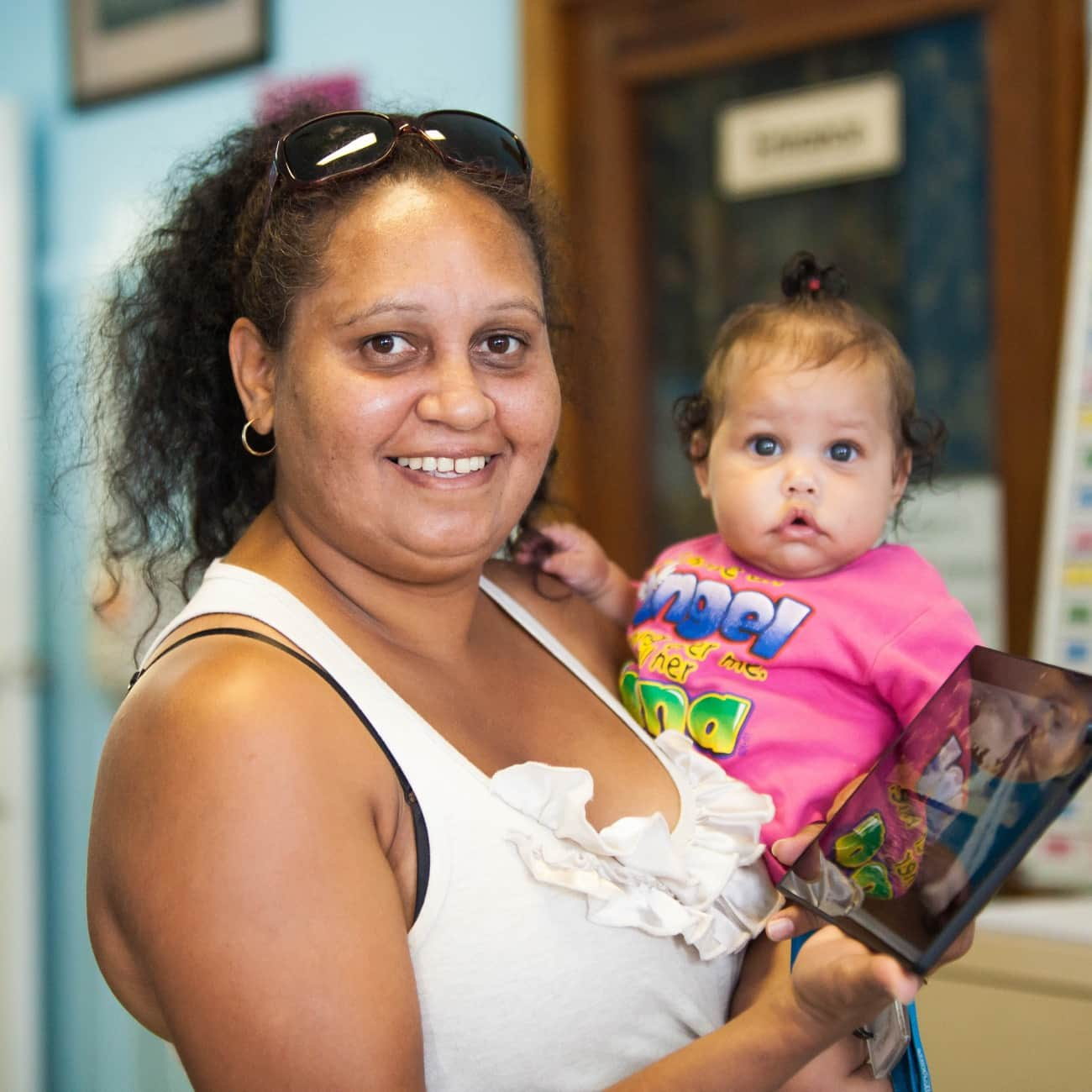 Mother holding baby smiling to camera