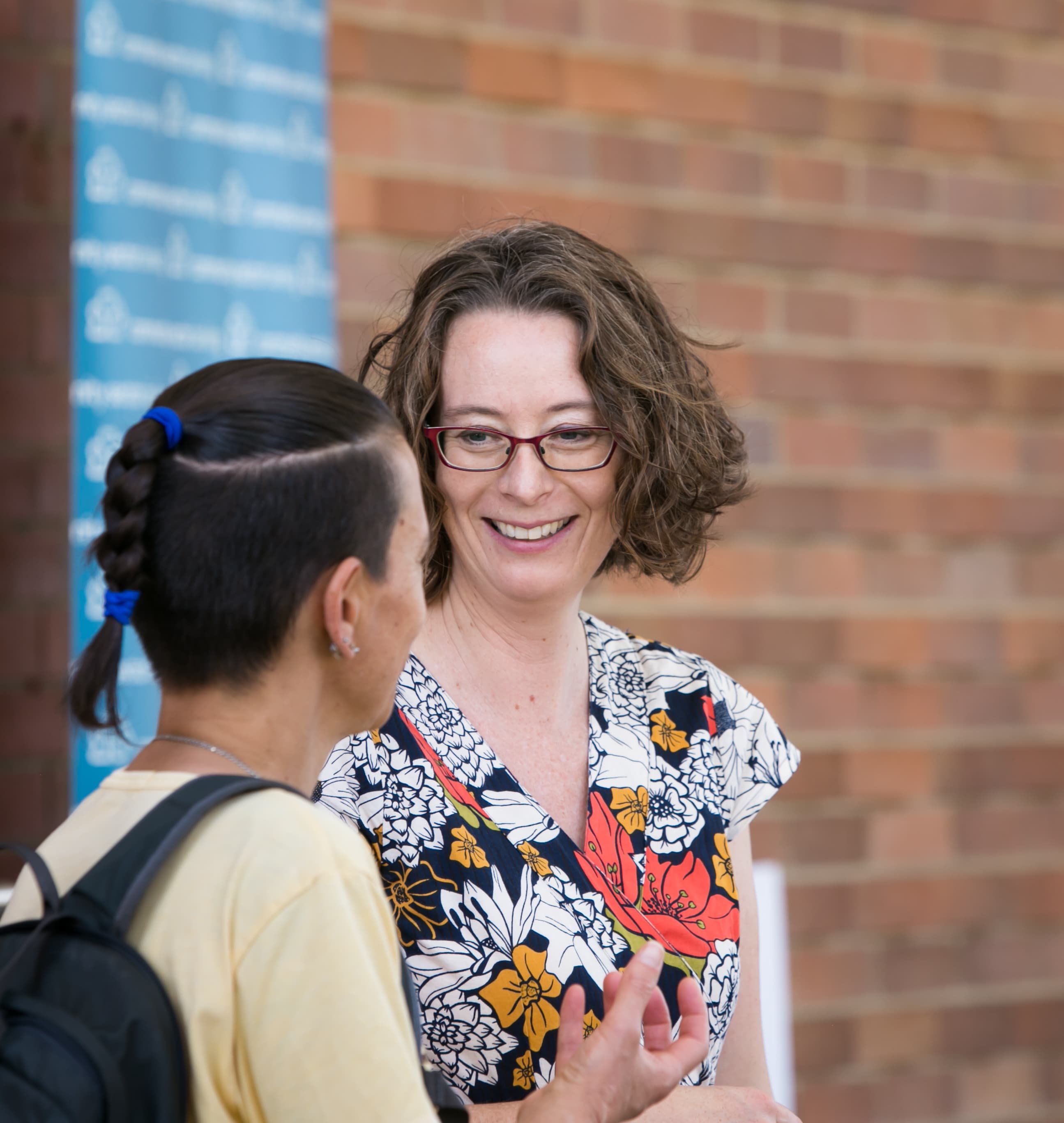 Image of two women smiling standing outside